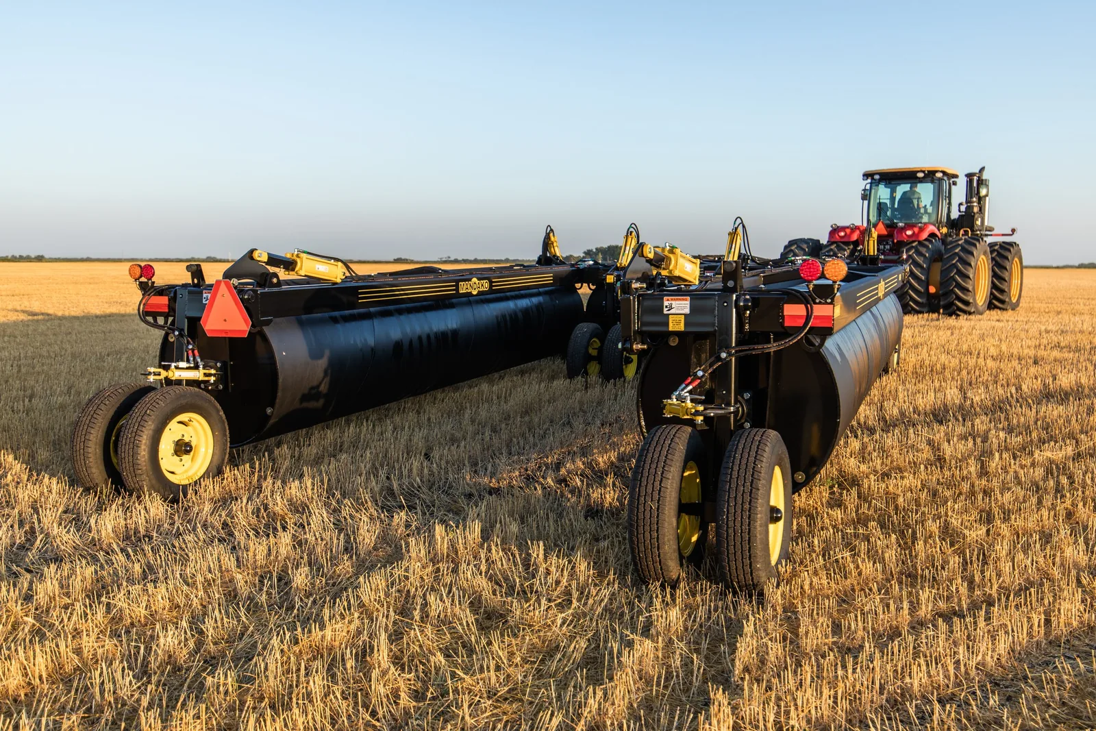 Mandako 5 PLEX LANDROLLER towed behind red tractor across crop stubble field